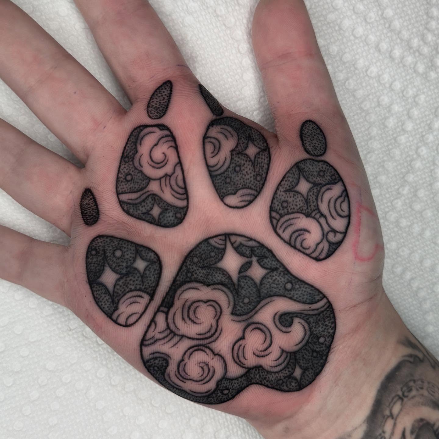 Paw print dotwork tattoo on the hand by James Boag