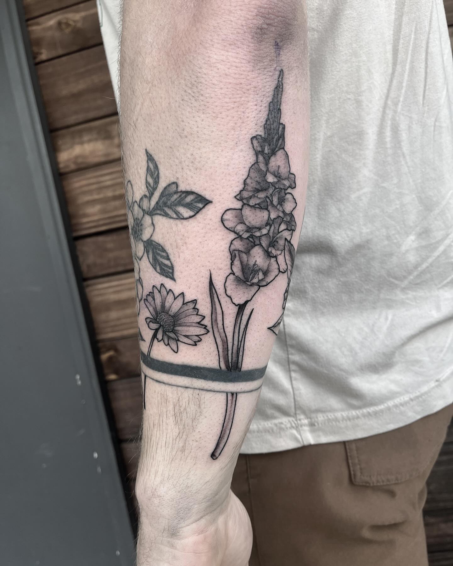 Flowers black and grey tattoo on the forearm by Dallas Davis