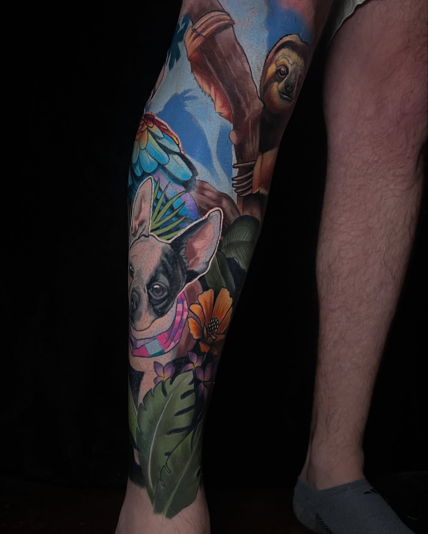 Dog and sloth realism tattoo on the calf by Emily Walker