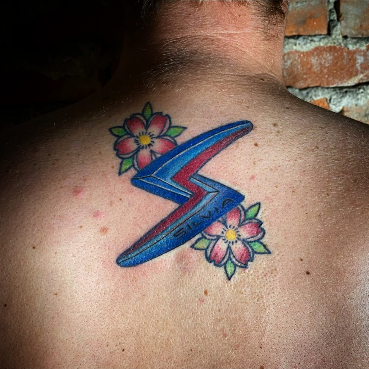 Lightning bolt with flowers American traditional tattoo on the back by Barbara Niblo