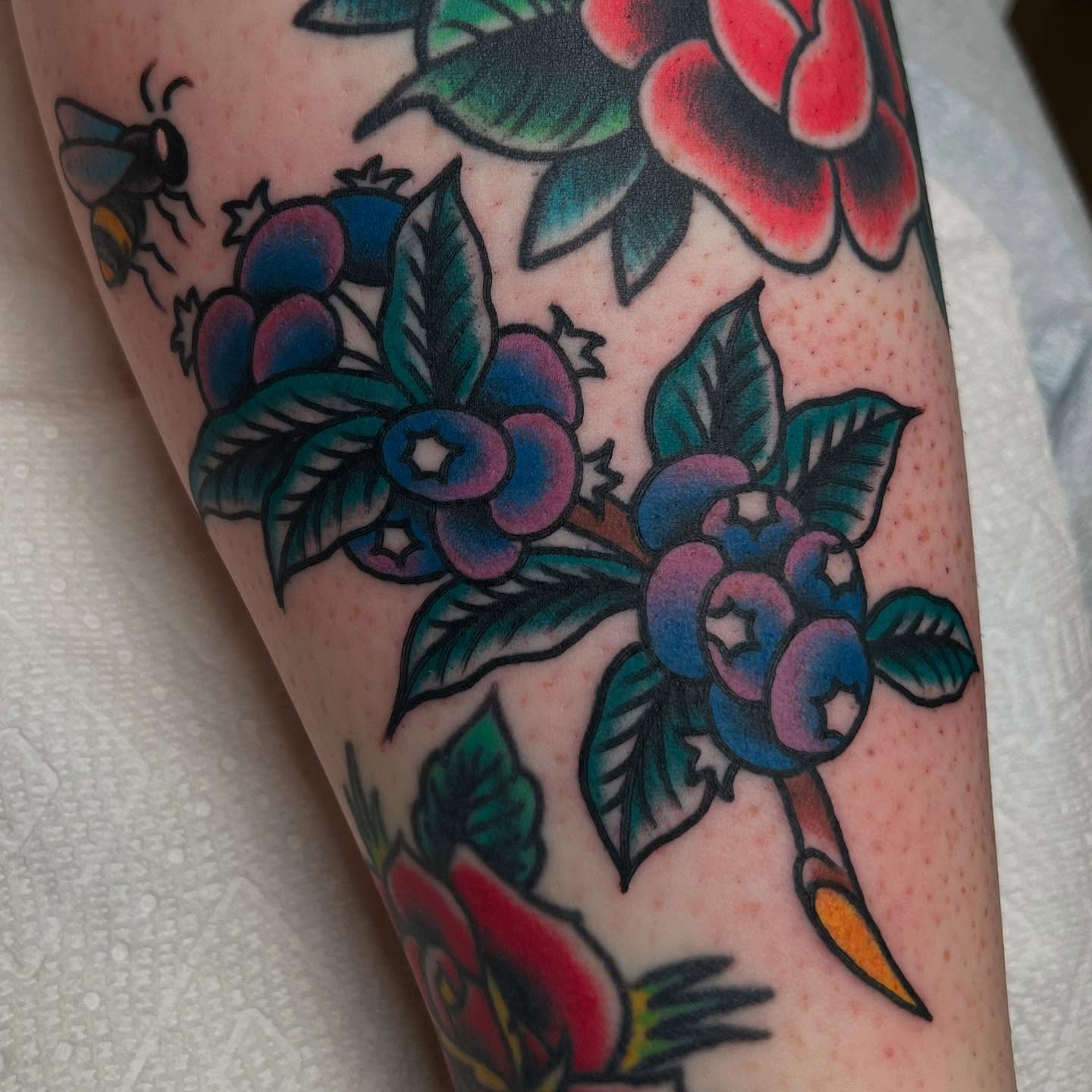Blueberries and flowers American traditional tattoo on the forearm by Zach Roman, Madison, Wisconsin