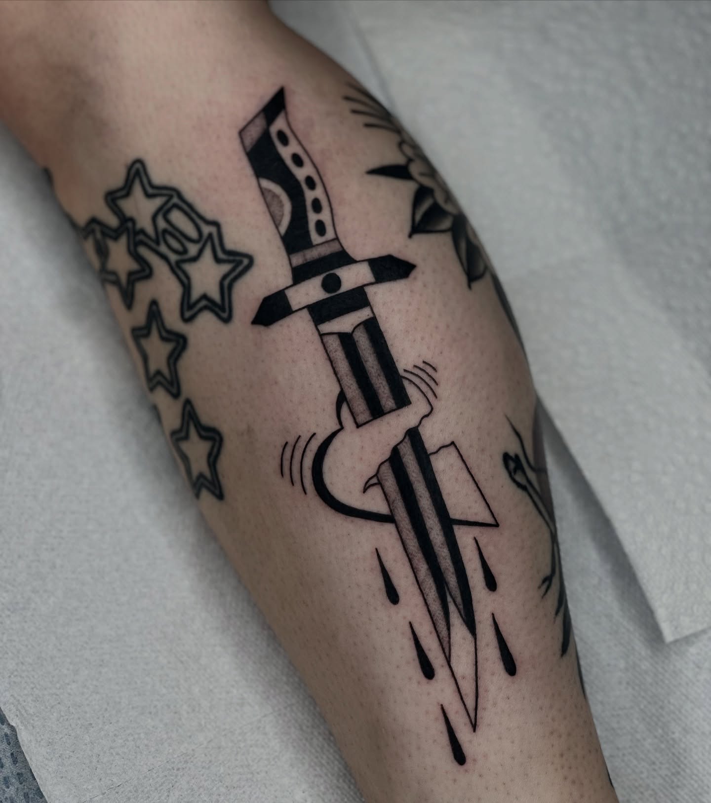Sword and stars black and grey tattoo on the forearm by Maks