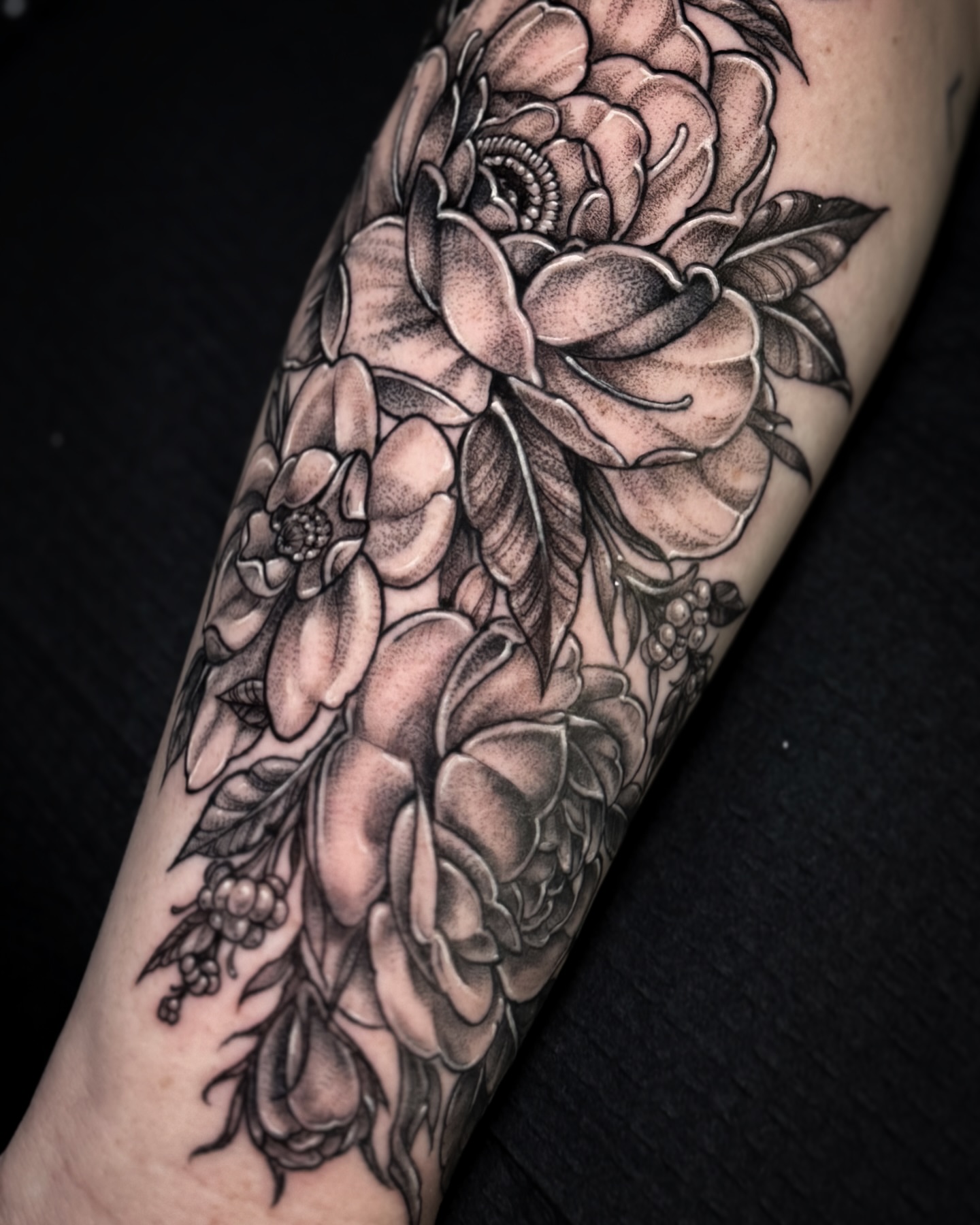 Floral bouquet black and grey tattoo on the forearm by Cristen Aro