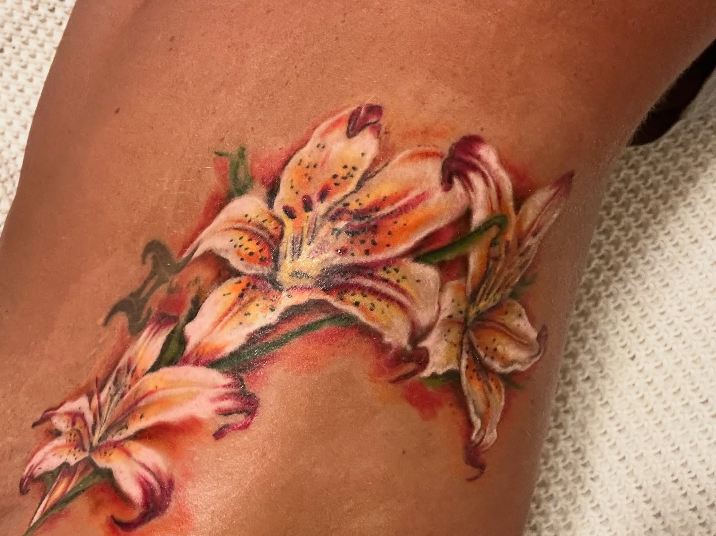 Lilies realism tattoo on the thigh by Chris Allen Taylor