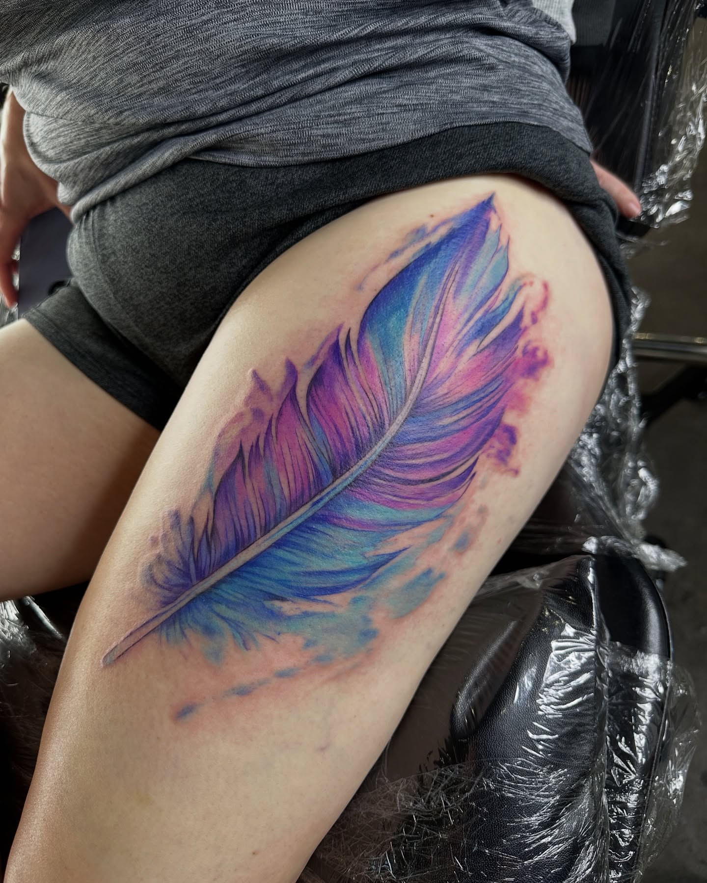 Feather watercolor tattoo on the thigh by Cameron Hobbs, Woodbridge, Virginia