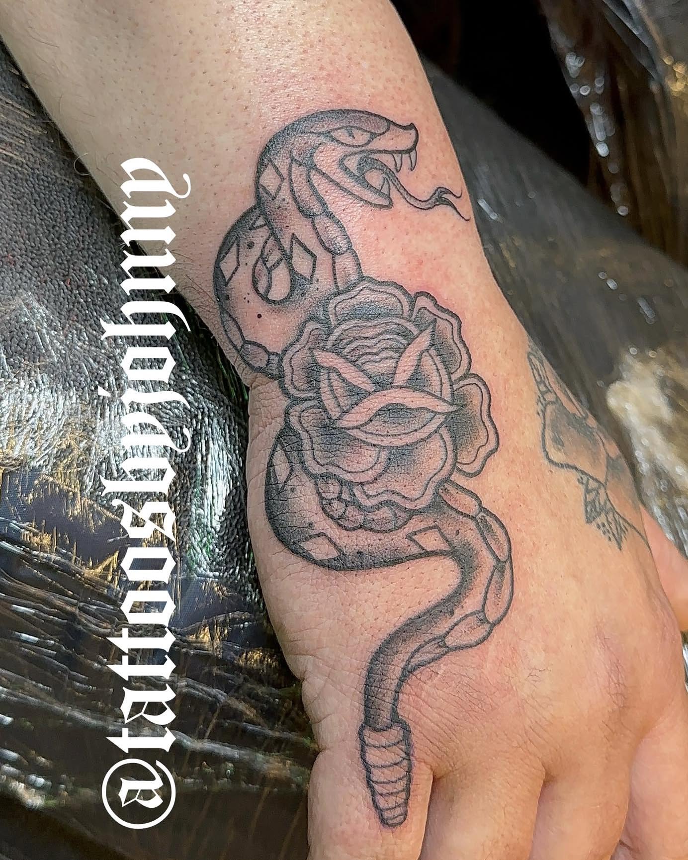 Snake and rose black and grey tattoo on the hand by Johnny Sepulveda