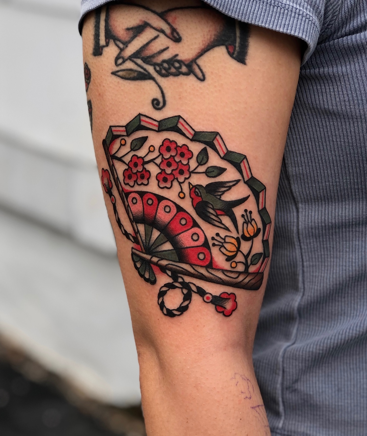Bird and cherry blossoms American traditional tattoo on the forearm by EVA Traditional Tattoos