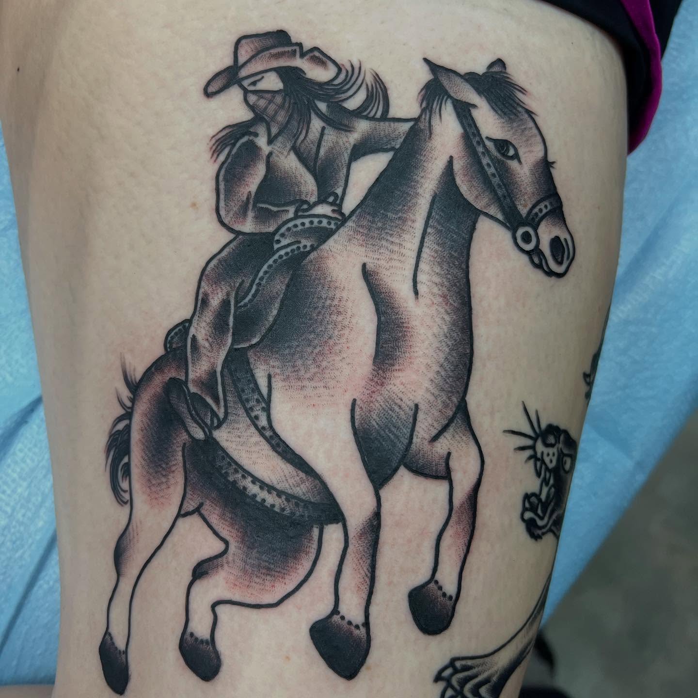 Cowboy riding horse black and grey tattoo on the thigh by doodle