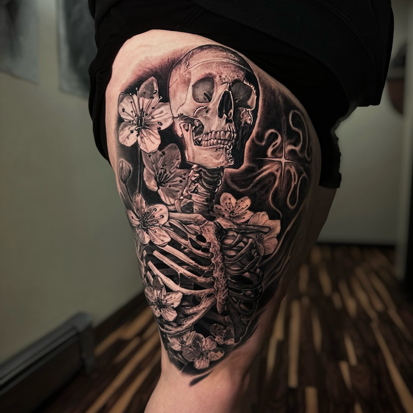 Skeleton with flowers realism tattoo on the thigh by Jesse White, Mentor, Ohio