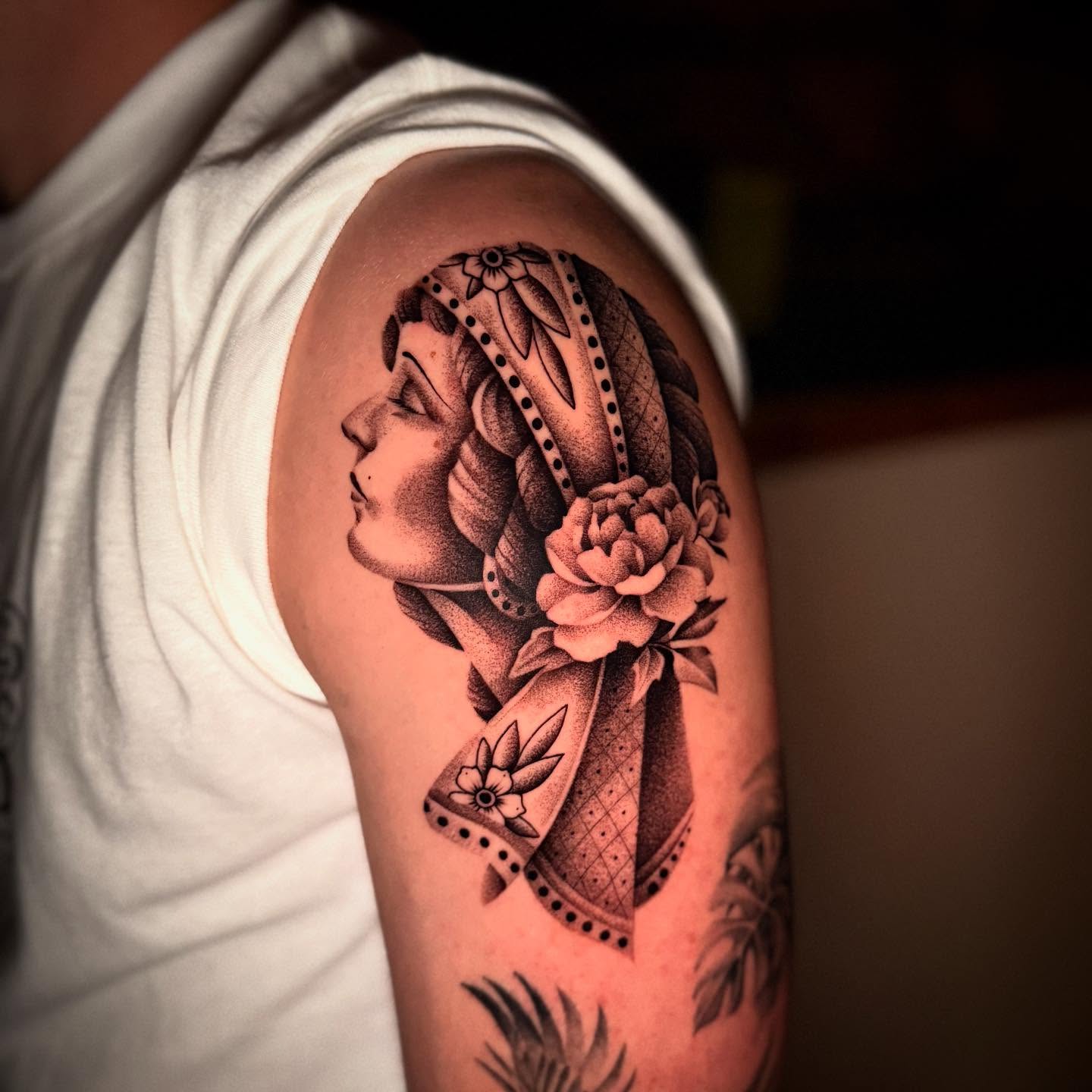 Woman with floral headdress American traditional tattoo on the shoulder by Jacob Deirfield, Circleville, Ohio