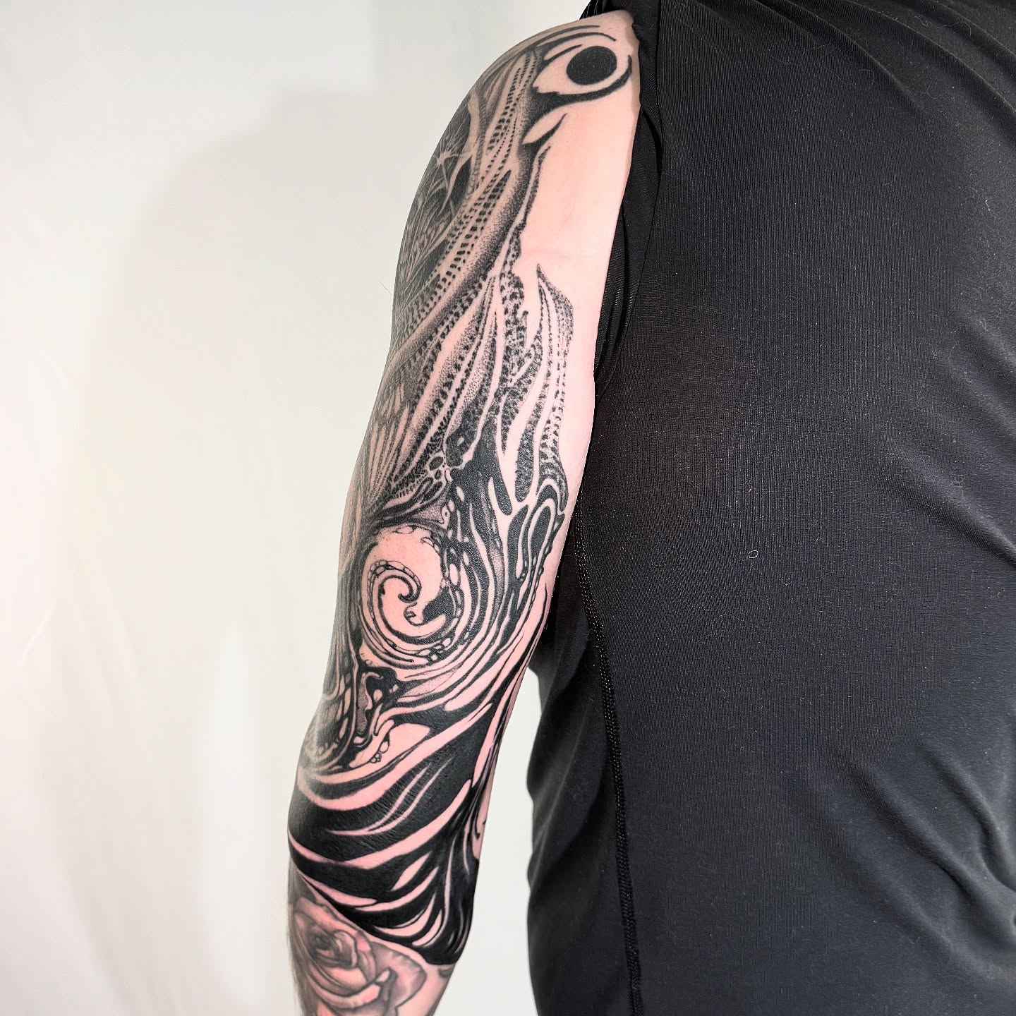 Fish and wave black and grey tattoo on the upper arm by H I R A  L U P E - tattoo artist, Oakland, California