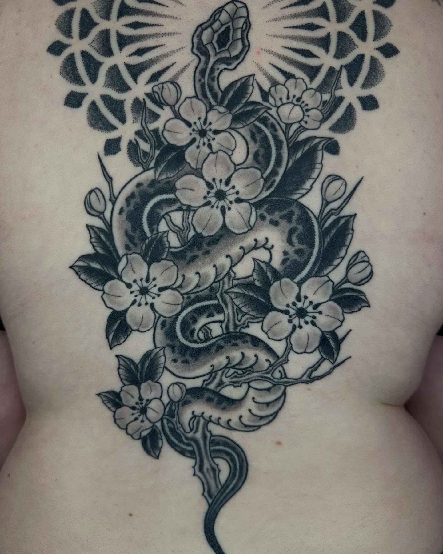 Snake and flowers American traditional tattoo on the torso by Owlyn Madrone