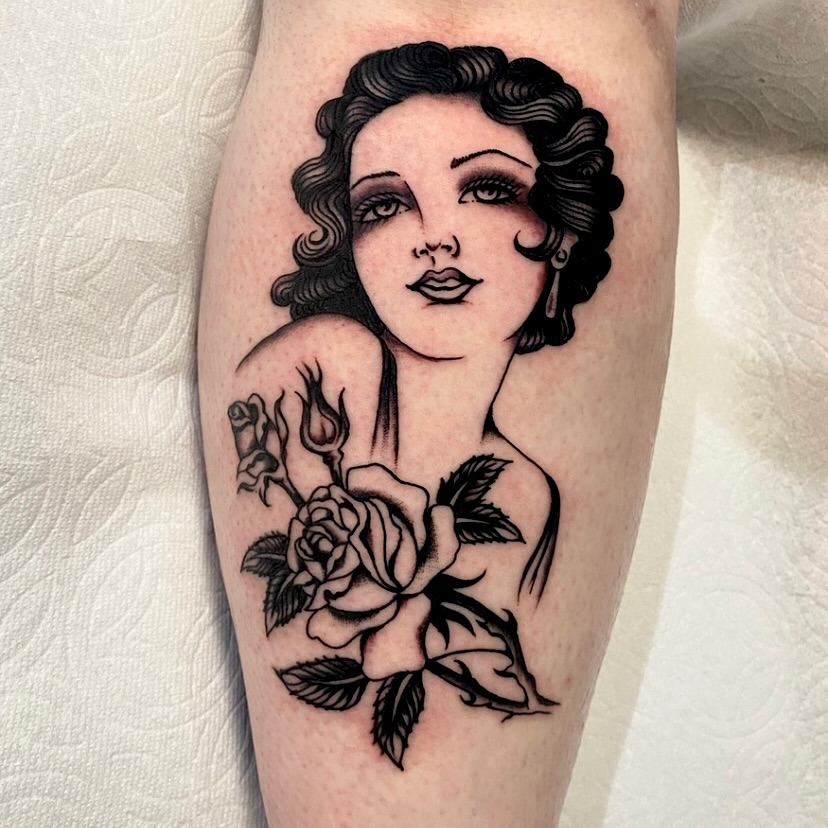 Woman with roses American traditional tattoo on the forearm by Haley Tucker, Sebastopol, California