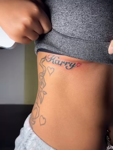 Name tattoo with floral elements lettering tattoo on the torso by Mc X Happo