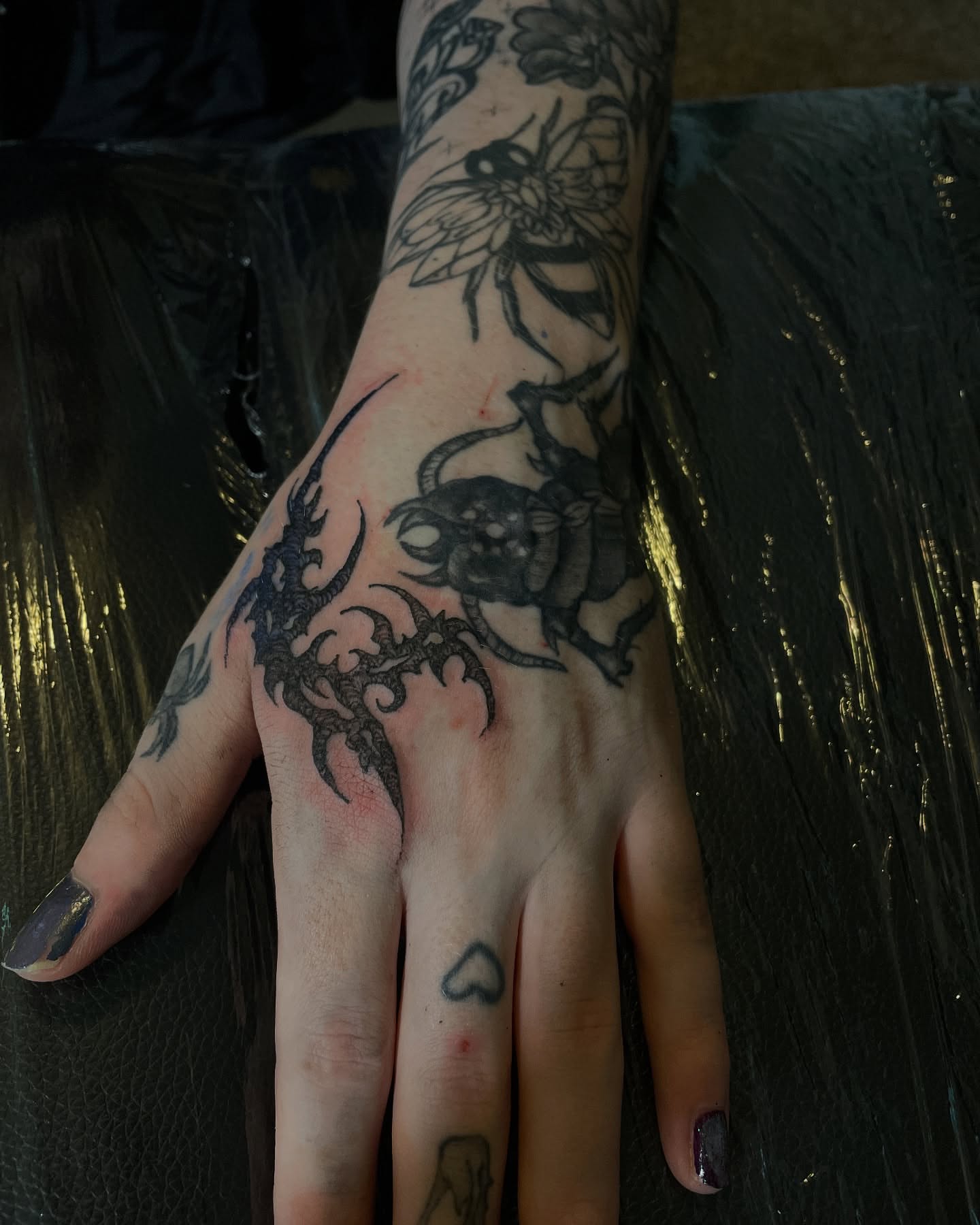 Insect and floral black and grey tattoo on the hand by ɴᴏᴍᴢ ᴅʏsᴇᴍʙᴏᴅɪᴍᴇɴᴛ