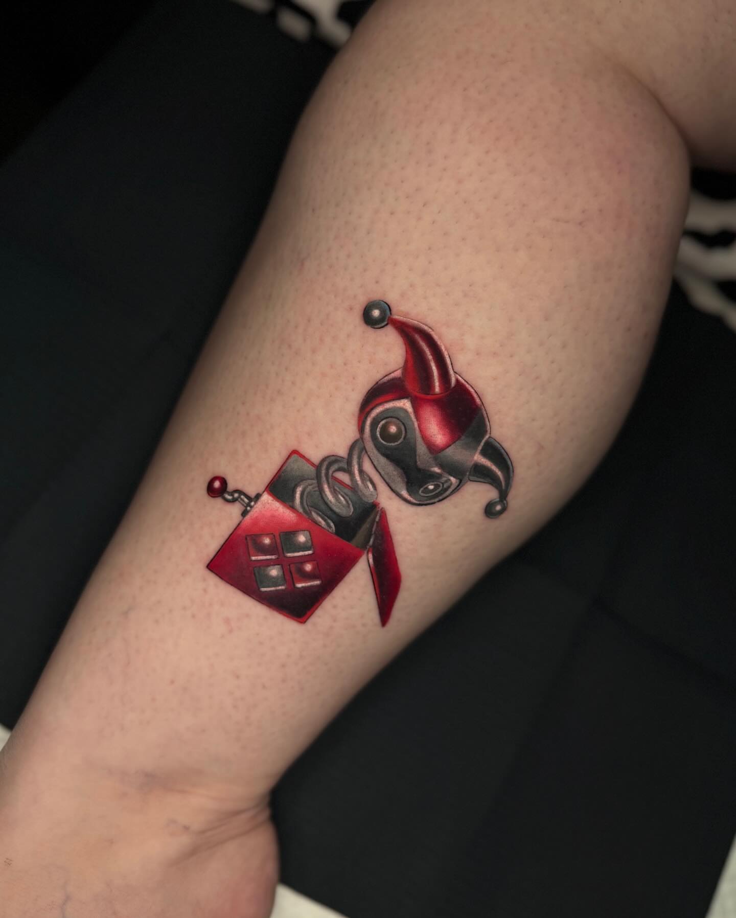Jester hat and box American traditional tattoo on the forearm by Mel