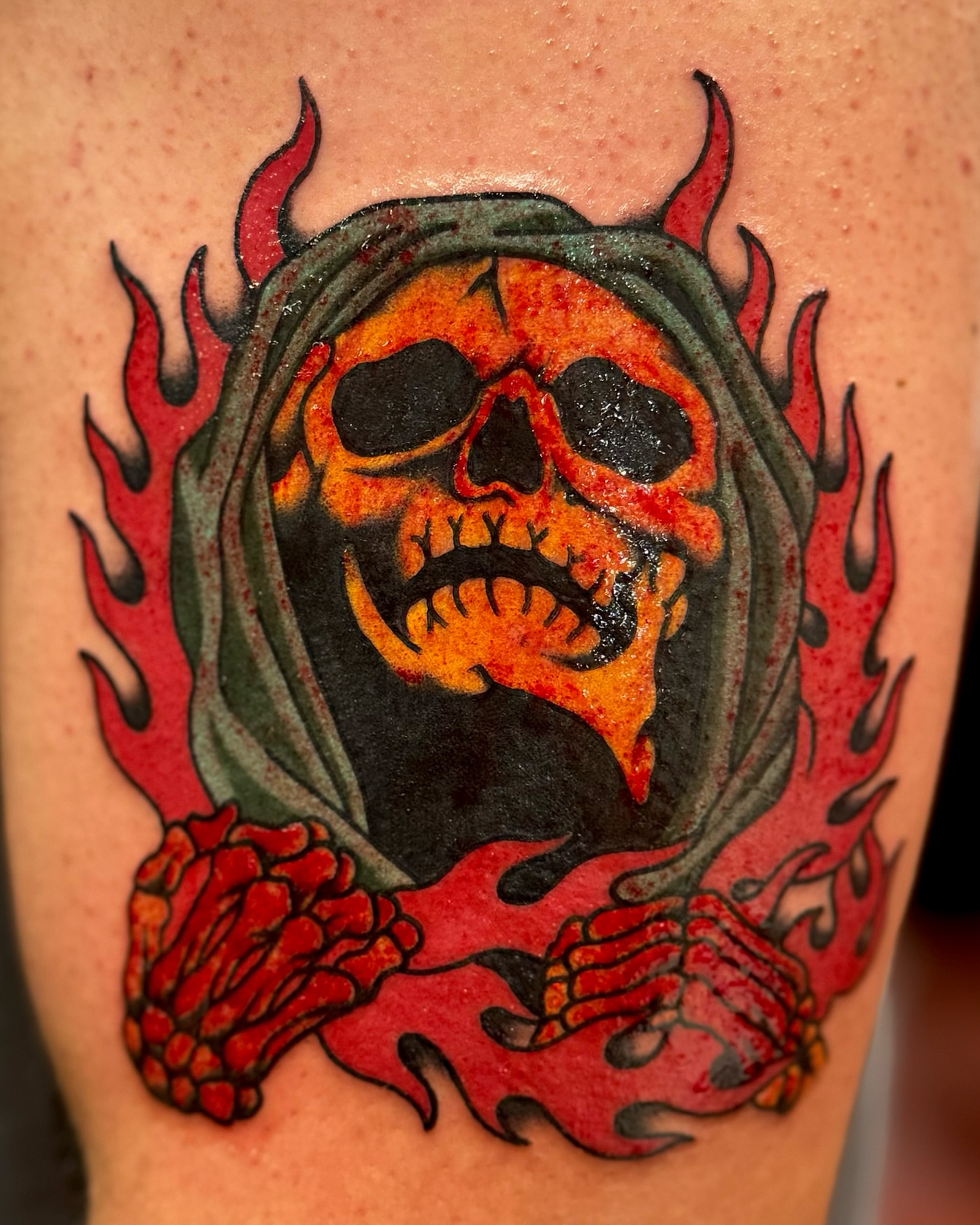 Flaming skull American traditional tattoo on the thigh by Ernie Rivera
