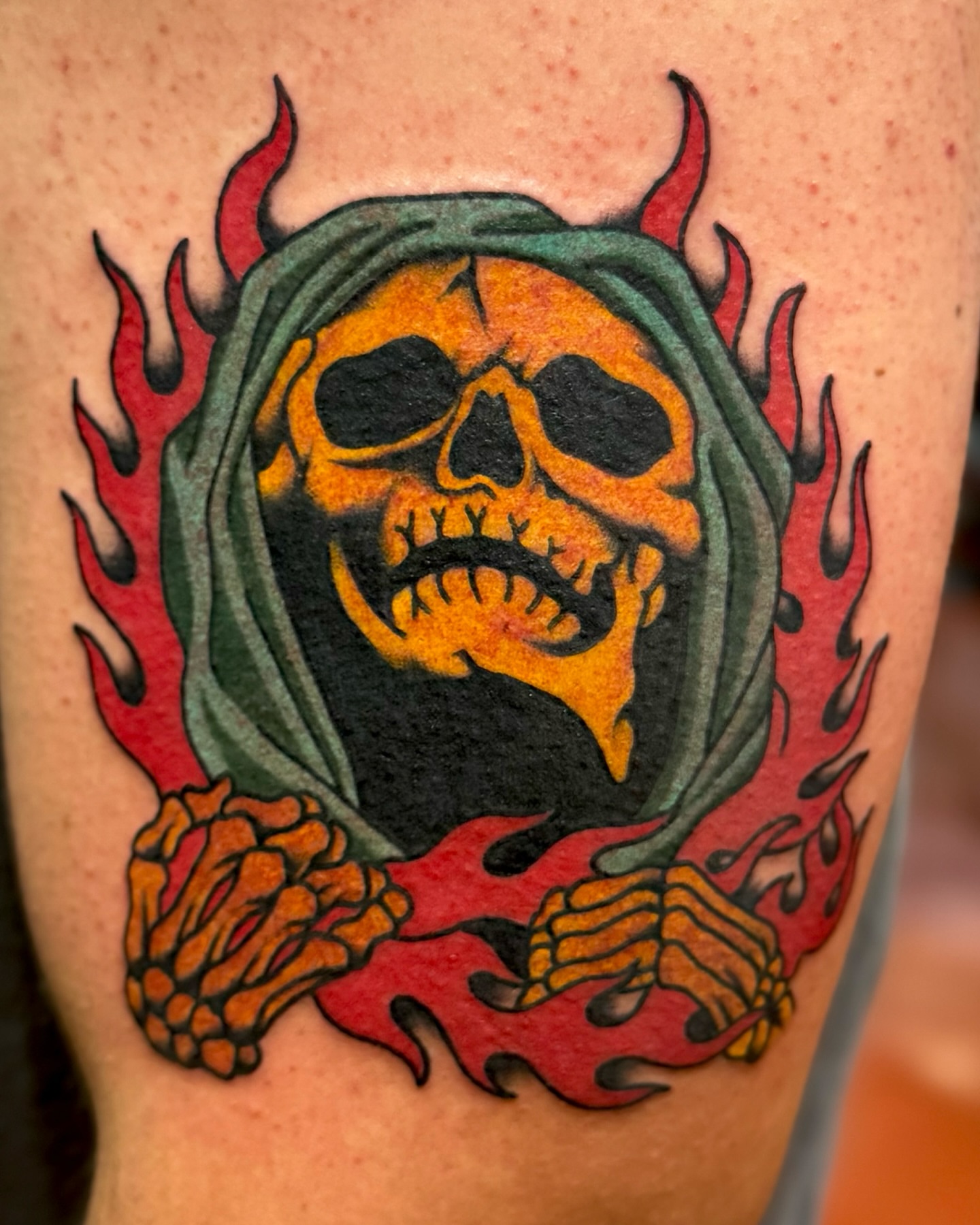 Skull with flames American traditional tattoo on the forearm by Ernie Rivera