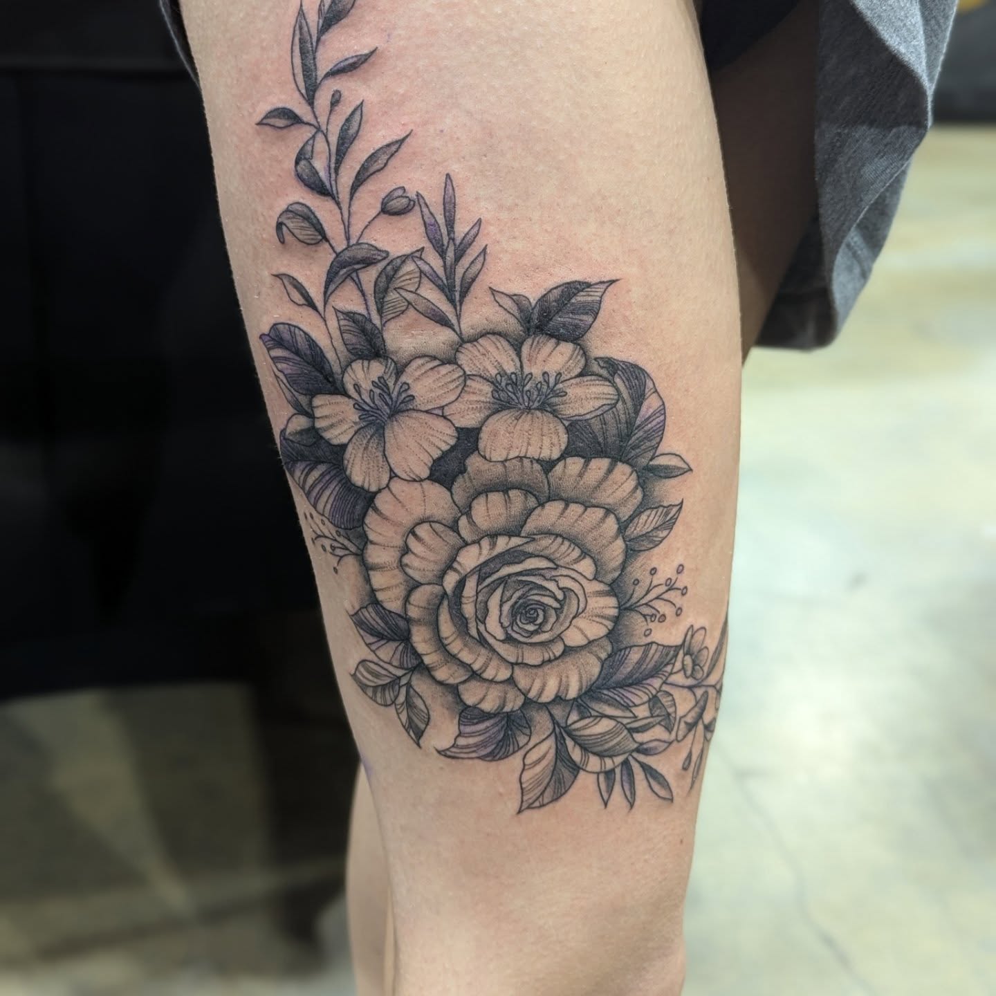 Floral bouquet realism tattoo on the thigh by Claudia Isabel Roman, El Paso, Texas