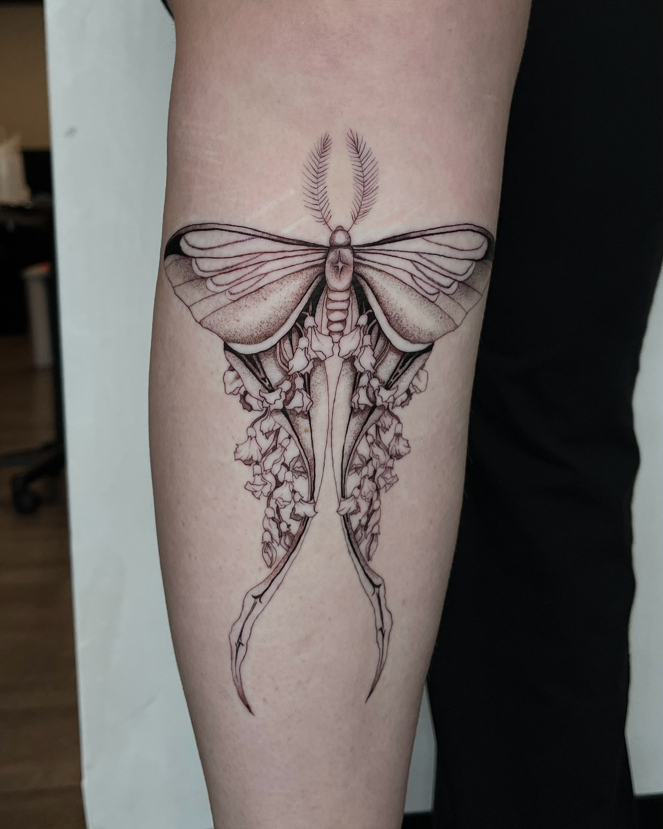 Moth and flowers dotwork tattoo on the forearm by Samantha