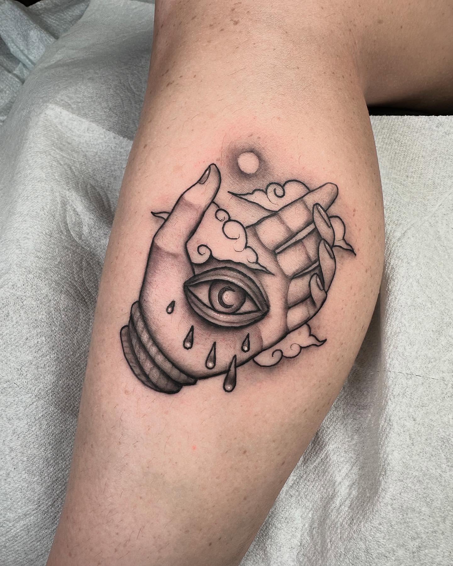 Eye and hand black and grey tattoo on the forearm by Lawrence Edwards