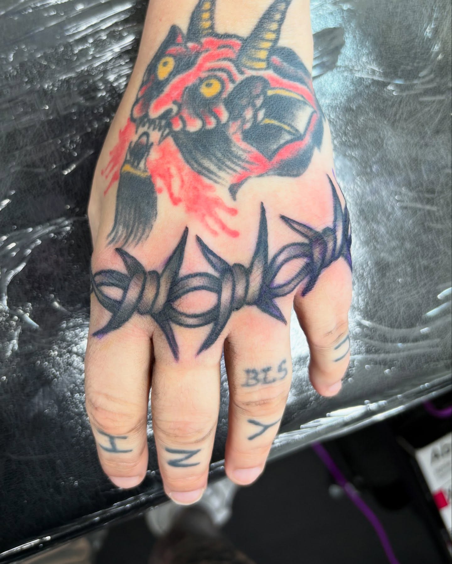 Demon head with barbed wire American traditional tattoo on the hand by Jamie Yuu, Minneapolis, Minnesota
