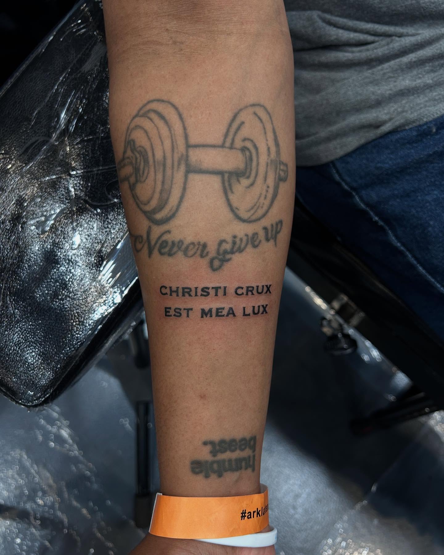 Barbell and motivational text black and grey tattoo on the forearm by Kipling Mcclellan