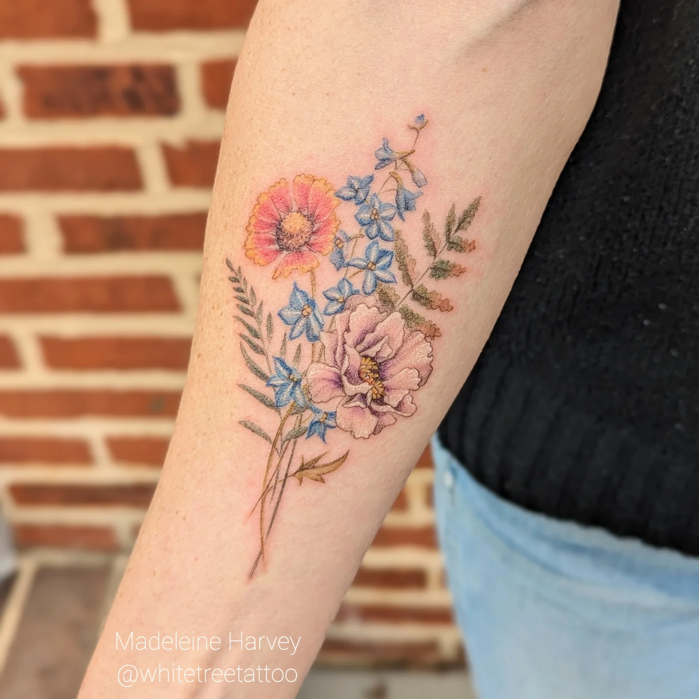 Floral bouquet watercolor tattoo on the forearm by Maddie