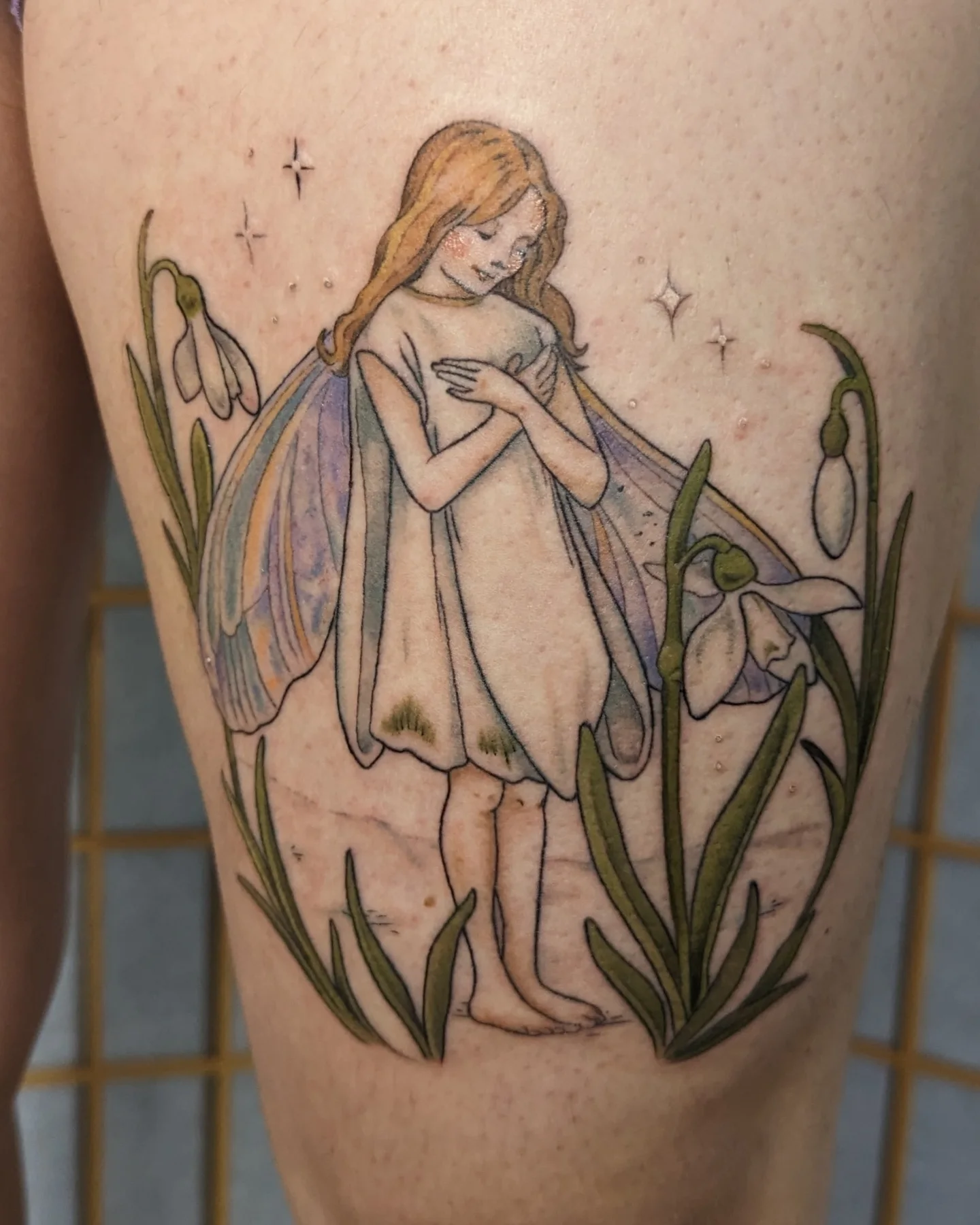 Fairy with snowdrops watercolor tattoo on the thigh by Jeanine, Providence, Rhode Island