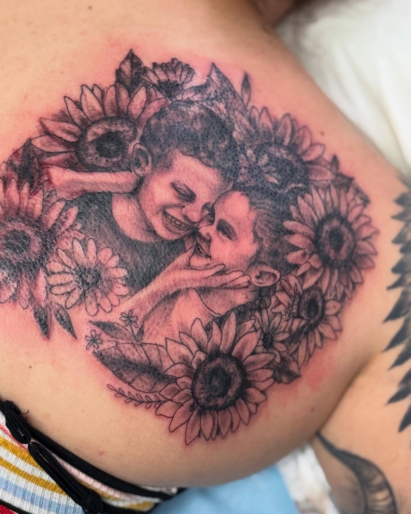 Sunflowers and couple realism tattoo on the chest by Tattoos By Trish
