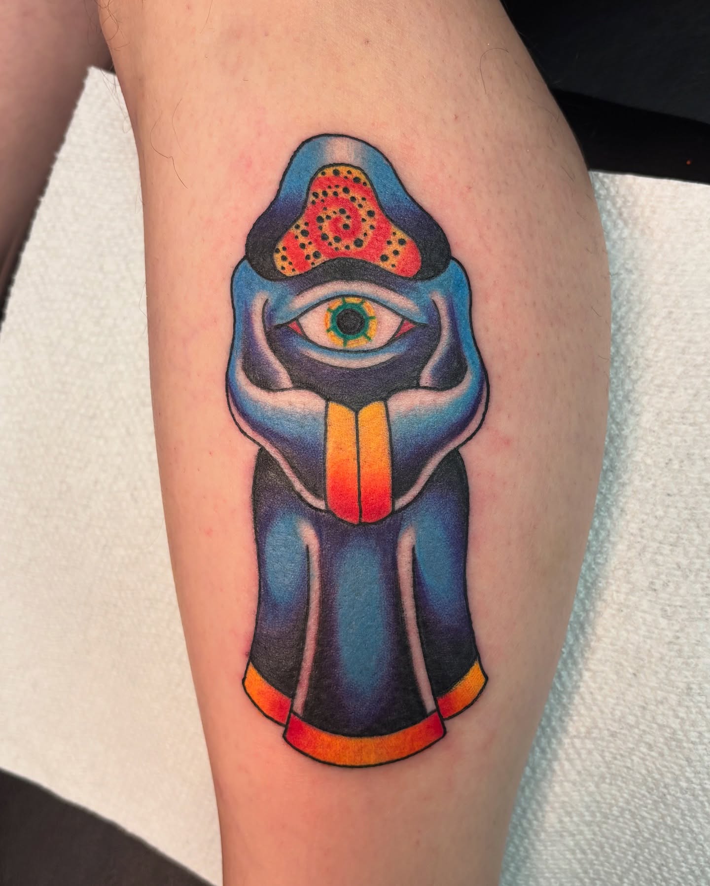 Mask with eye American traditional tattoo on the thigh by Jordan Wray