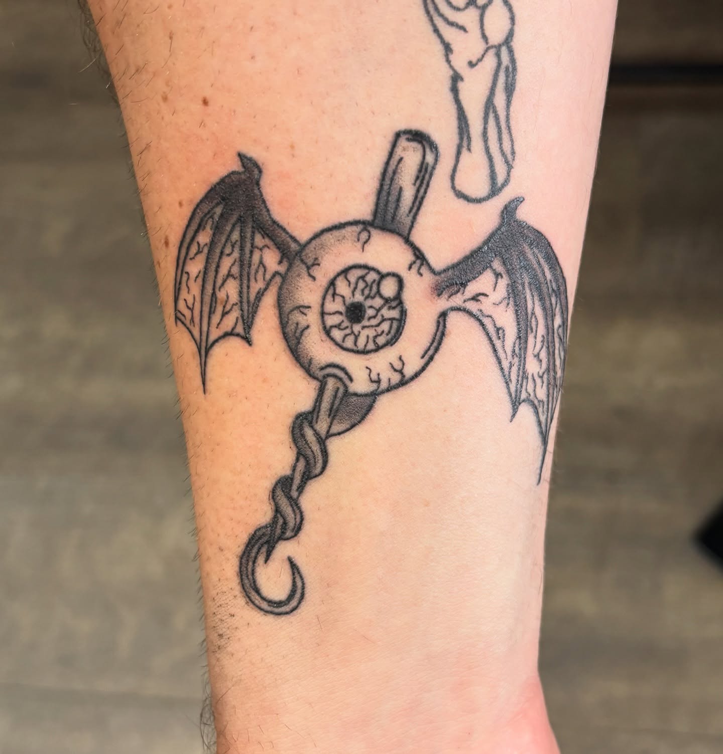 Winged key black and grey tattoo on the forearm by Tori Anderson, Minneapolis, Minnesota