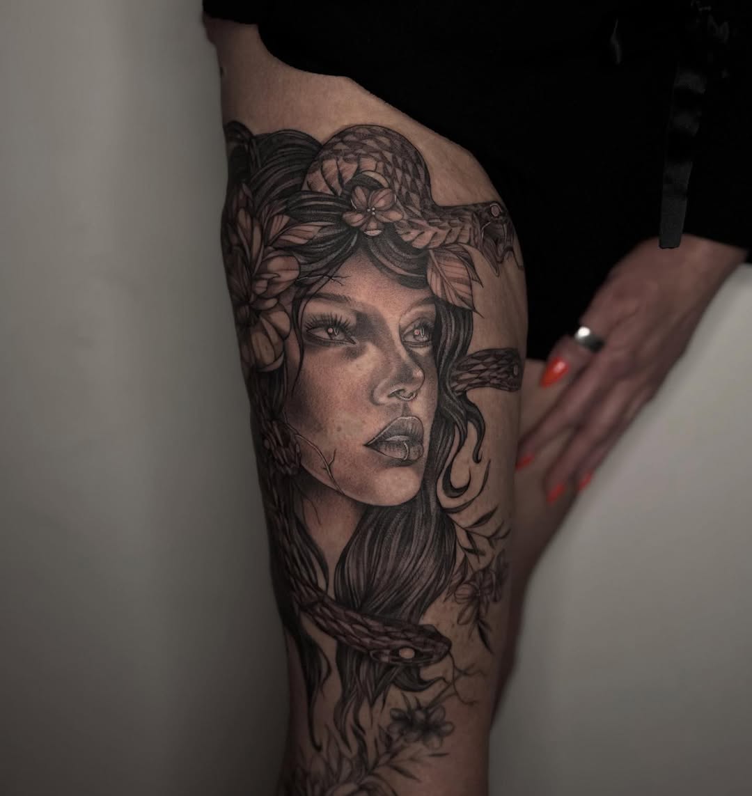 Medusa portrait with snakes and flowers realism tattoo on the thigh by Isabelle Kellar, San Diego, California