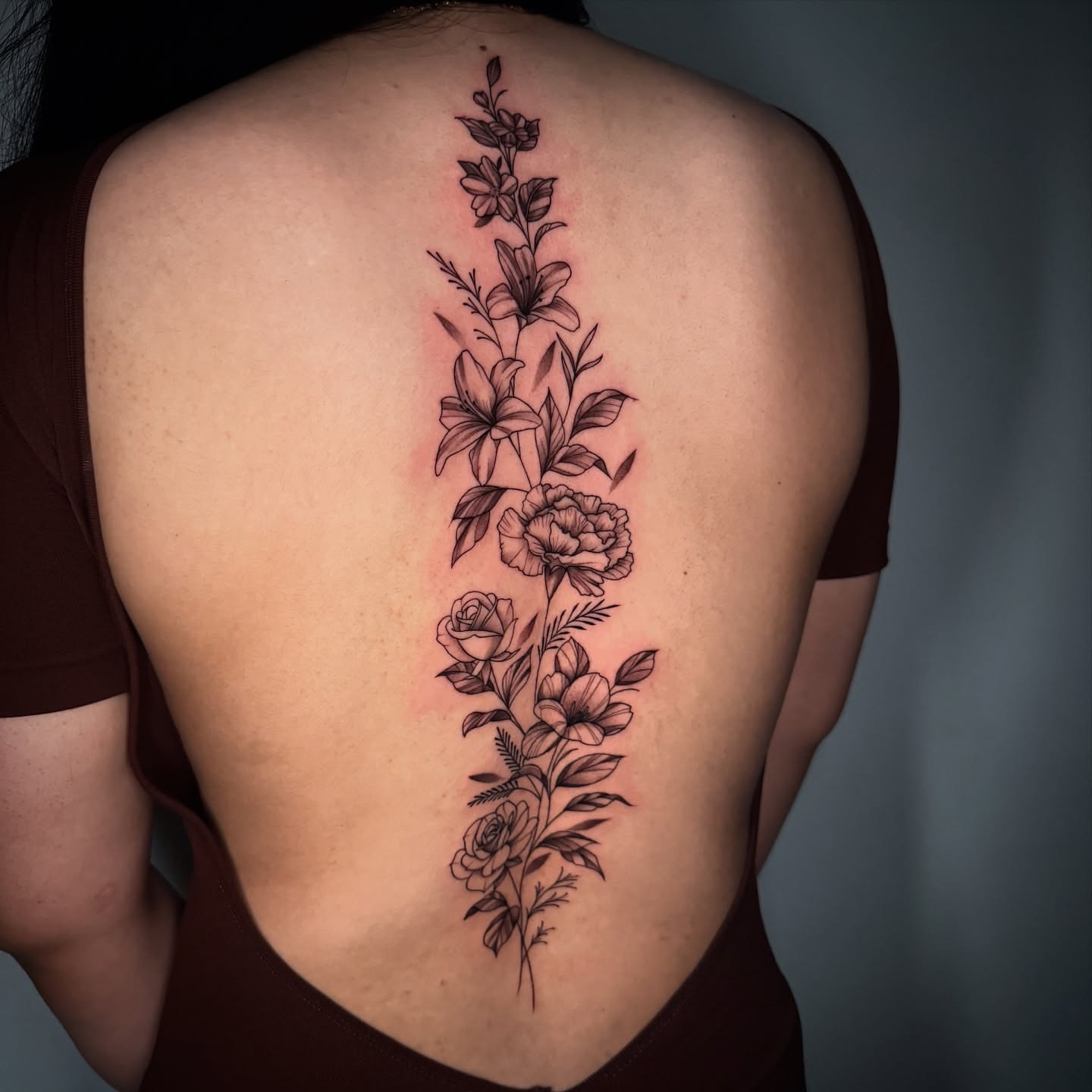 Floral arrangement black and grey tattoo on the back by Geo