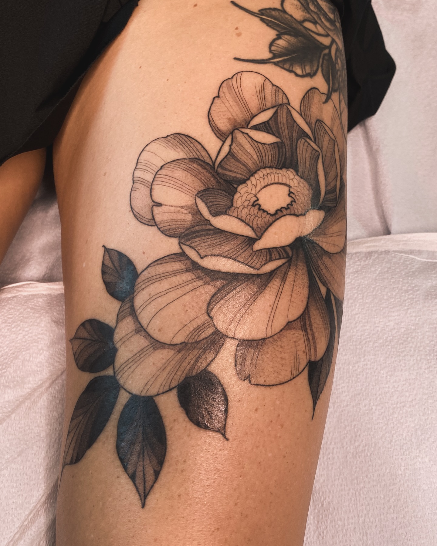 Peony black and grey tattoo on the thigh by Natasha Dickinson