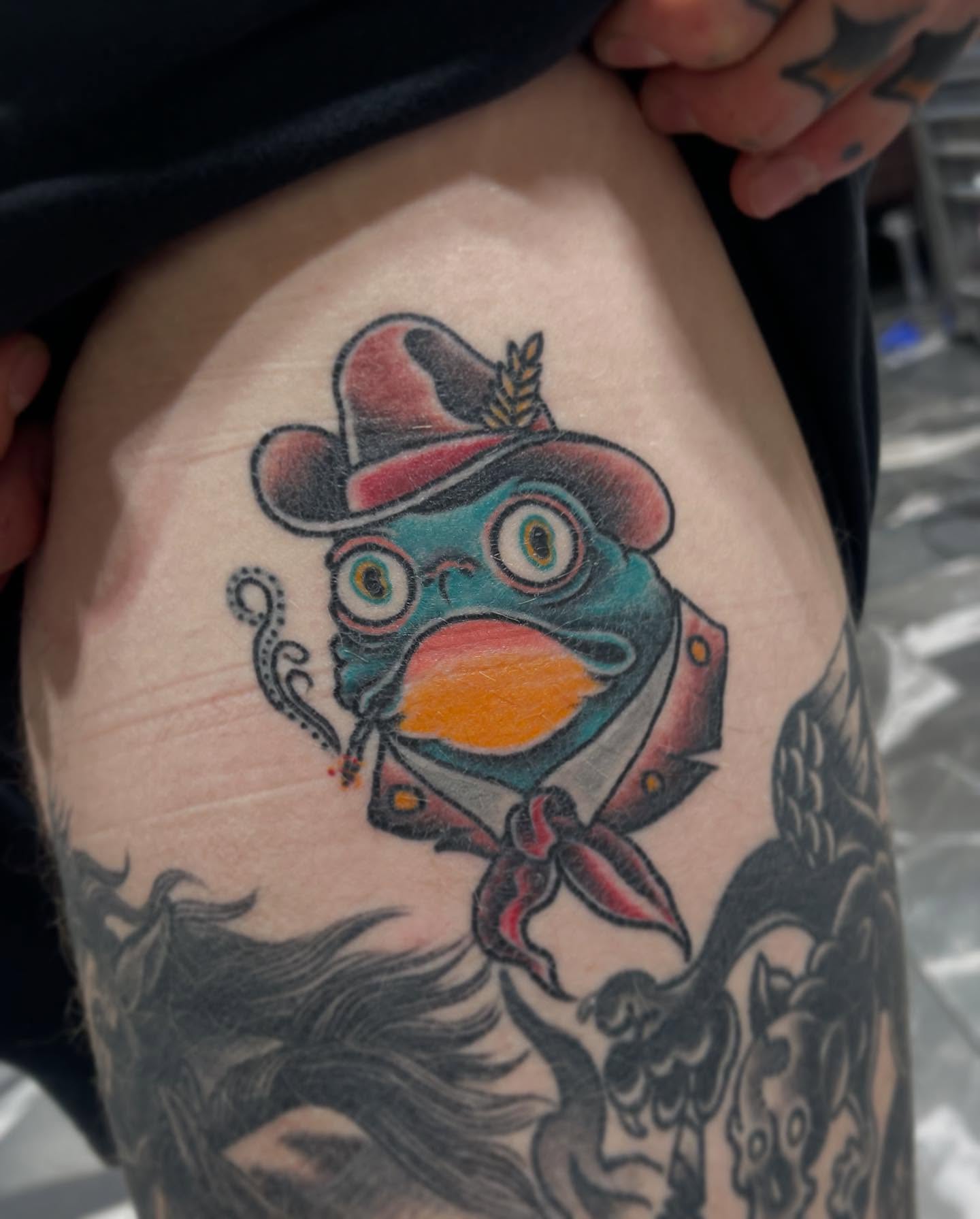Fish wearing hat American traditional tattoo on the thigh by Jaxson Eugene Brady-Hobart