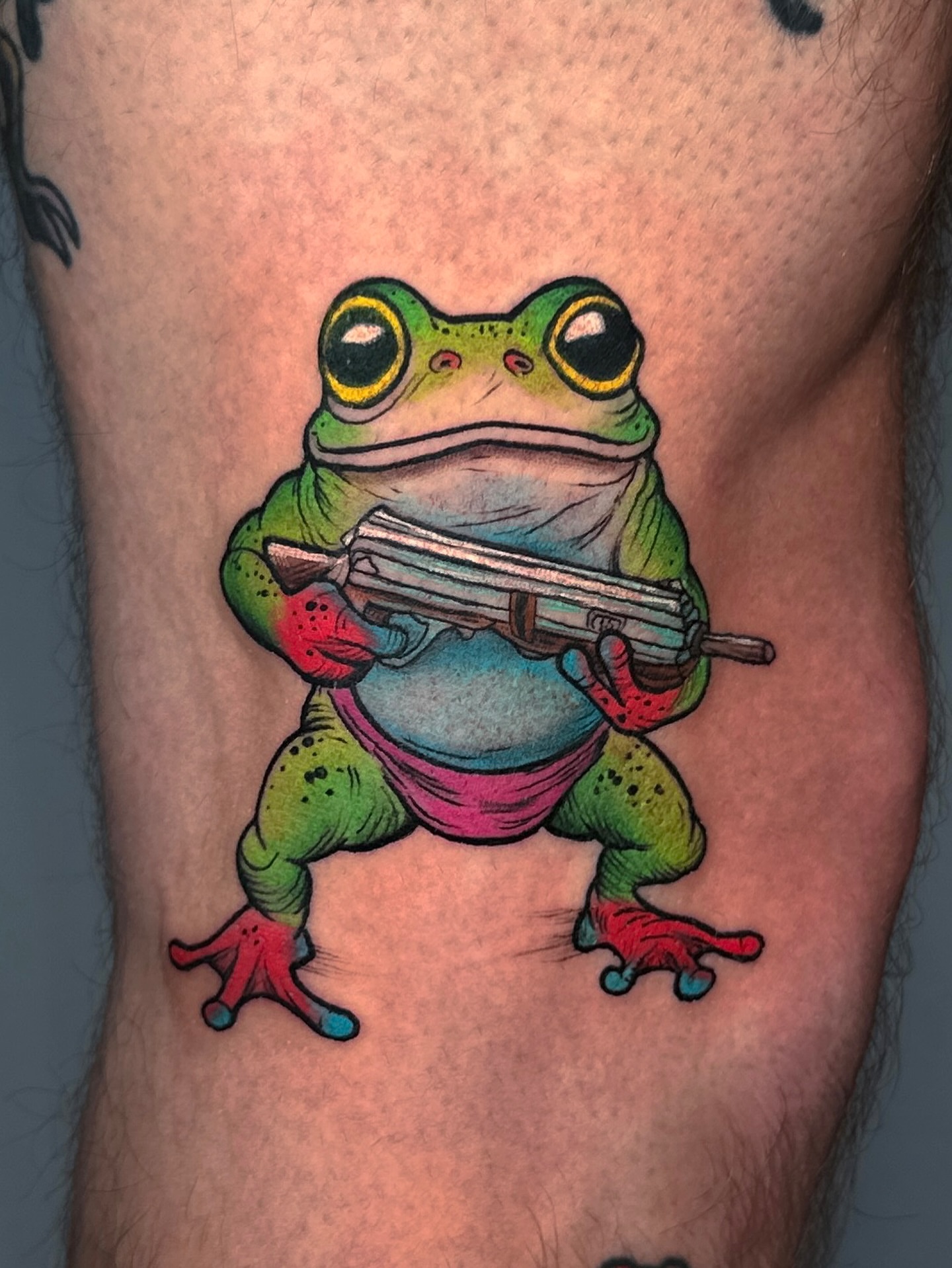 Frog with gun new school tattoo on the thigh by Tattoo Artist Los Angeles