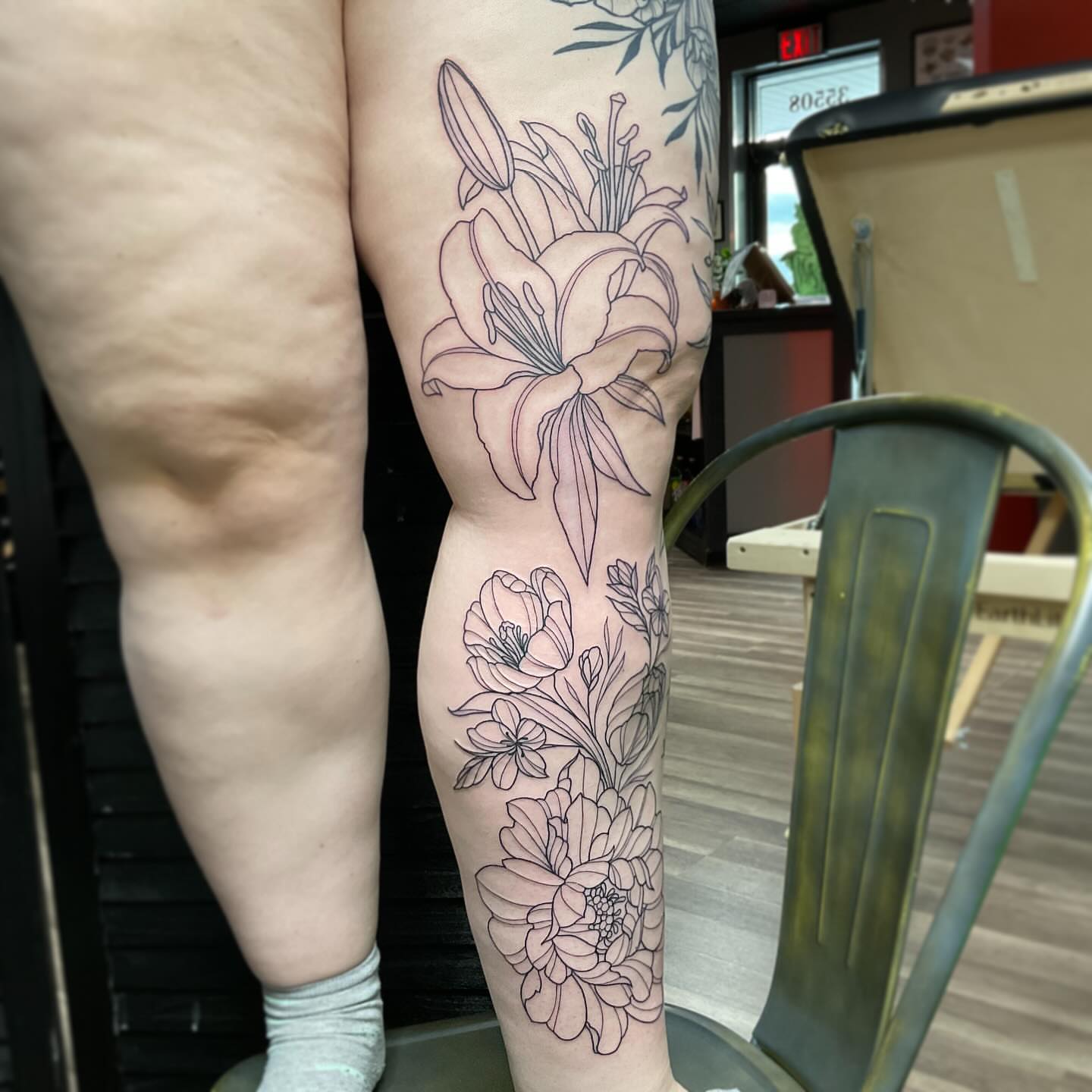 Lily and flowers black and grey tattoo on the calf by Michigan Tattoo Artist - Nadia Garver, Clinton Township, Michigan