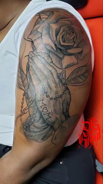 Praying hands with a rose realism tattoo by Dannie Blythewood