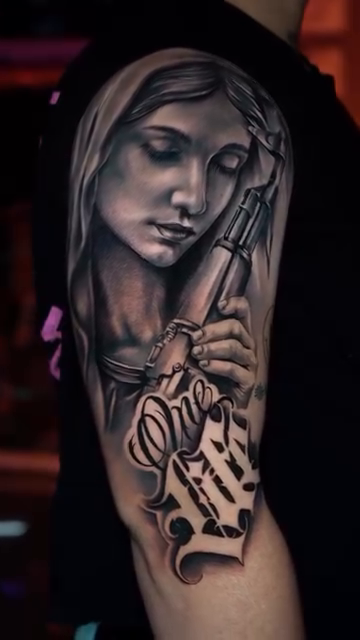 Virgin Mary holding a tattoo machine realism tattoo by Andres García Baeza