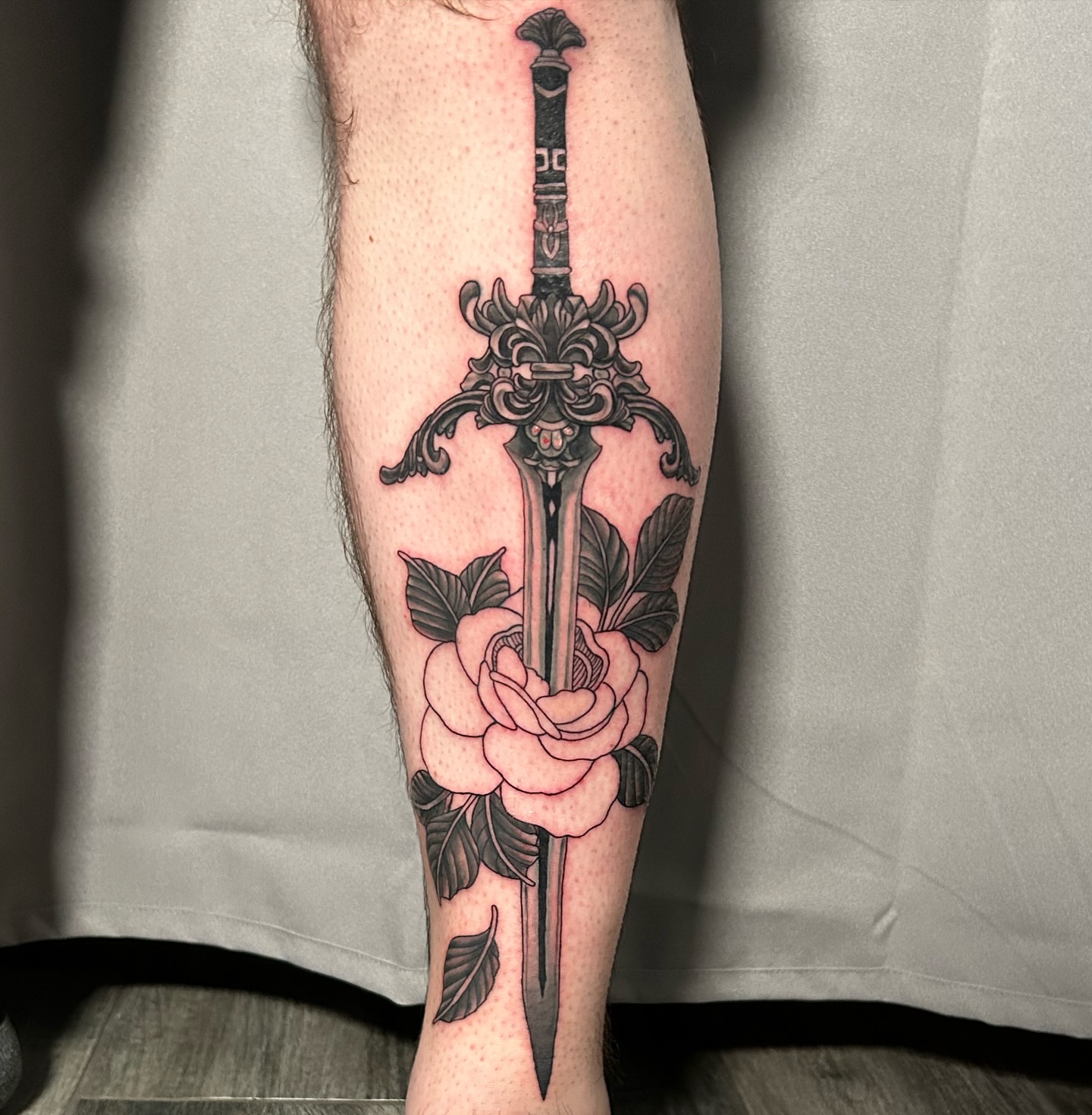 Sword and rose ornamental tattoo on the calf by Brittany Brutal