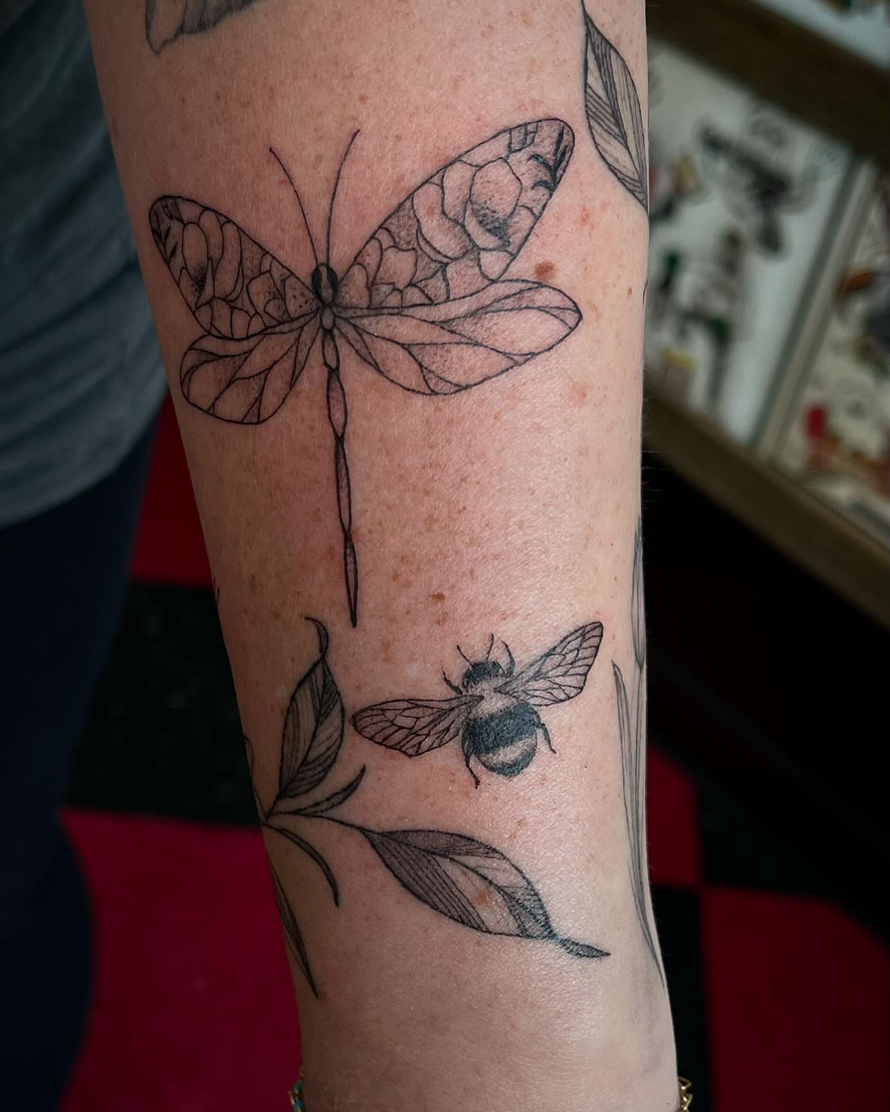 Butterfly and bee realism tattoo on the forearm by 𝕯𝖆𝖓𝖎