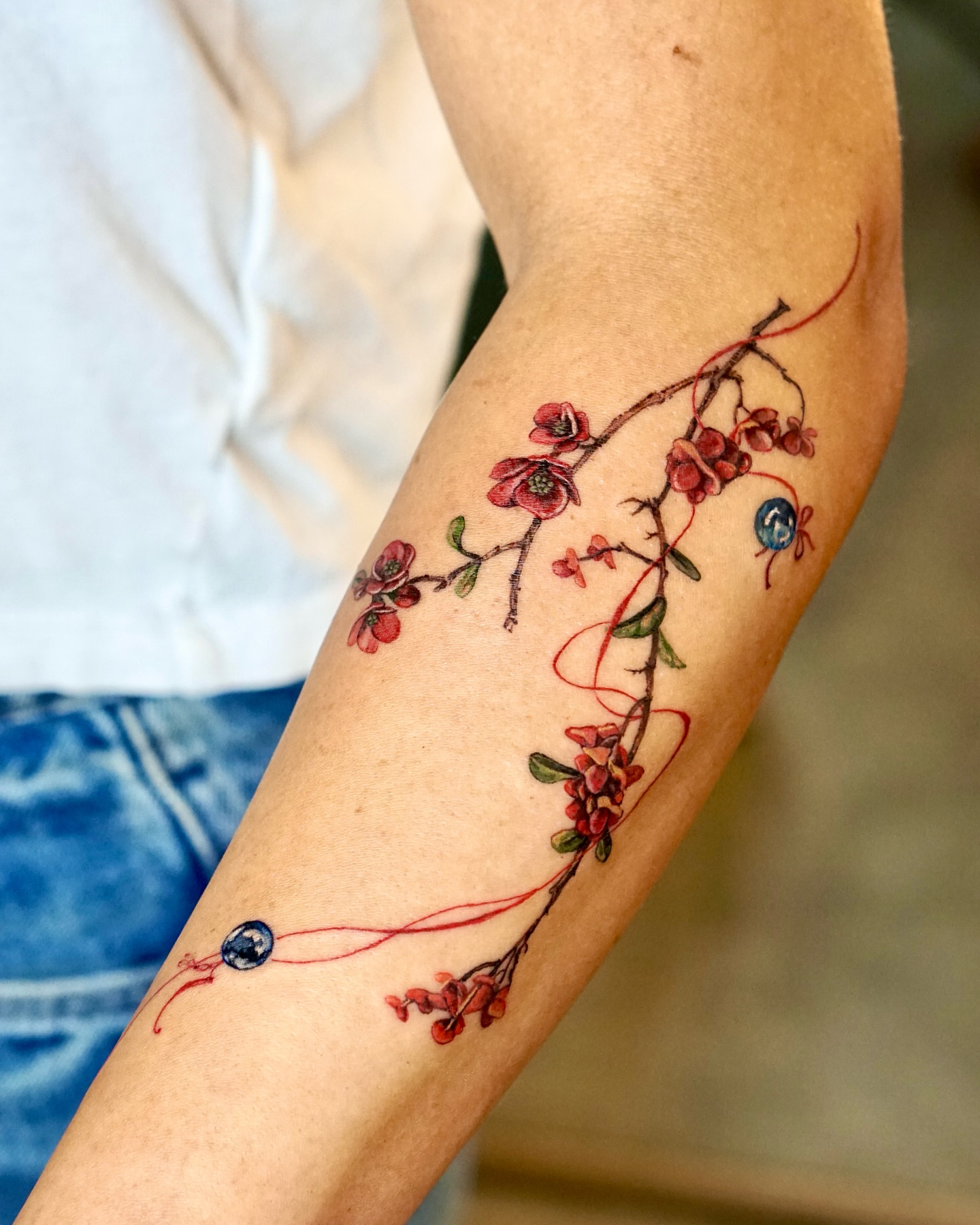 Cherry blossoms watercolor tattoo on the forearm by Isle