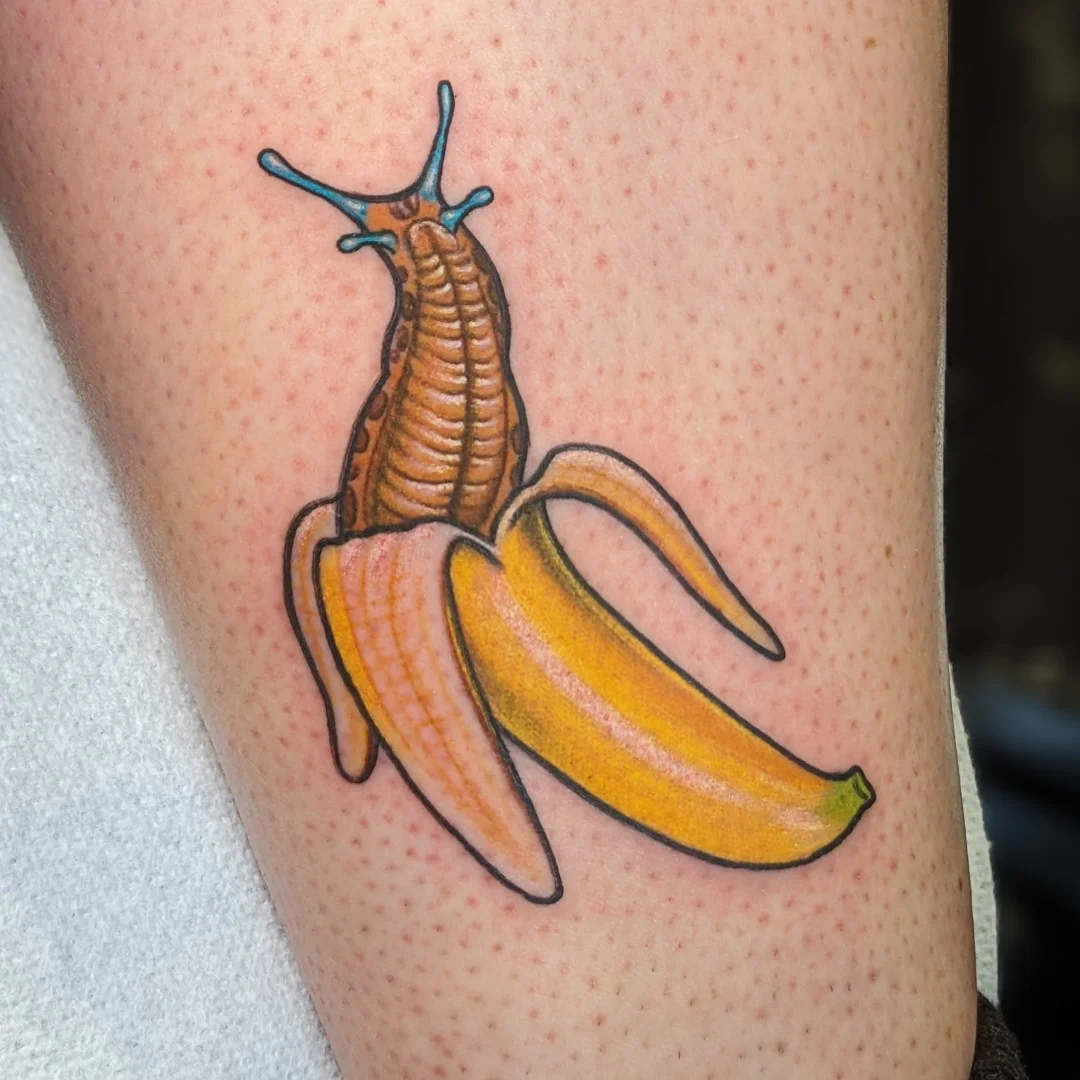 Banana peel and slug realism tattoo on the thigh by Matt Simmonds