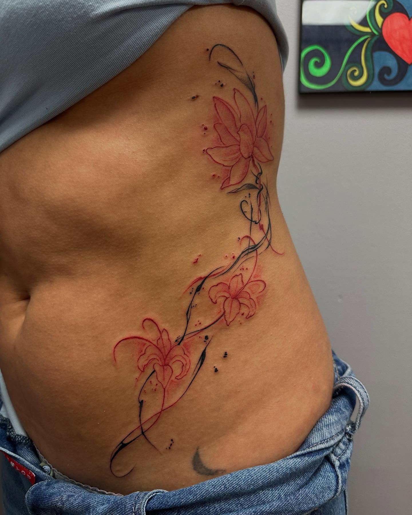 Lotus flowers watercolor tattoo on the ribs by Jan Xander