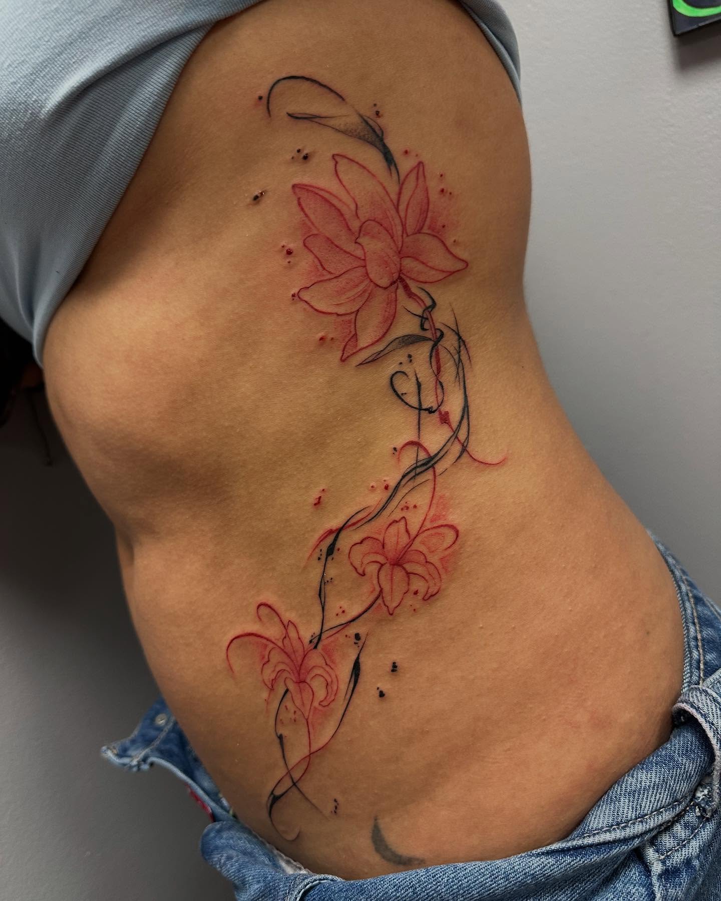 Lotus flowers new school tattoo on the ribs by Jan Xander