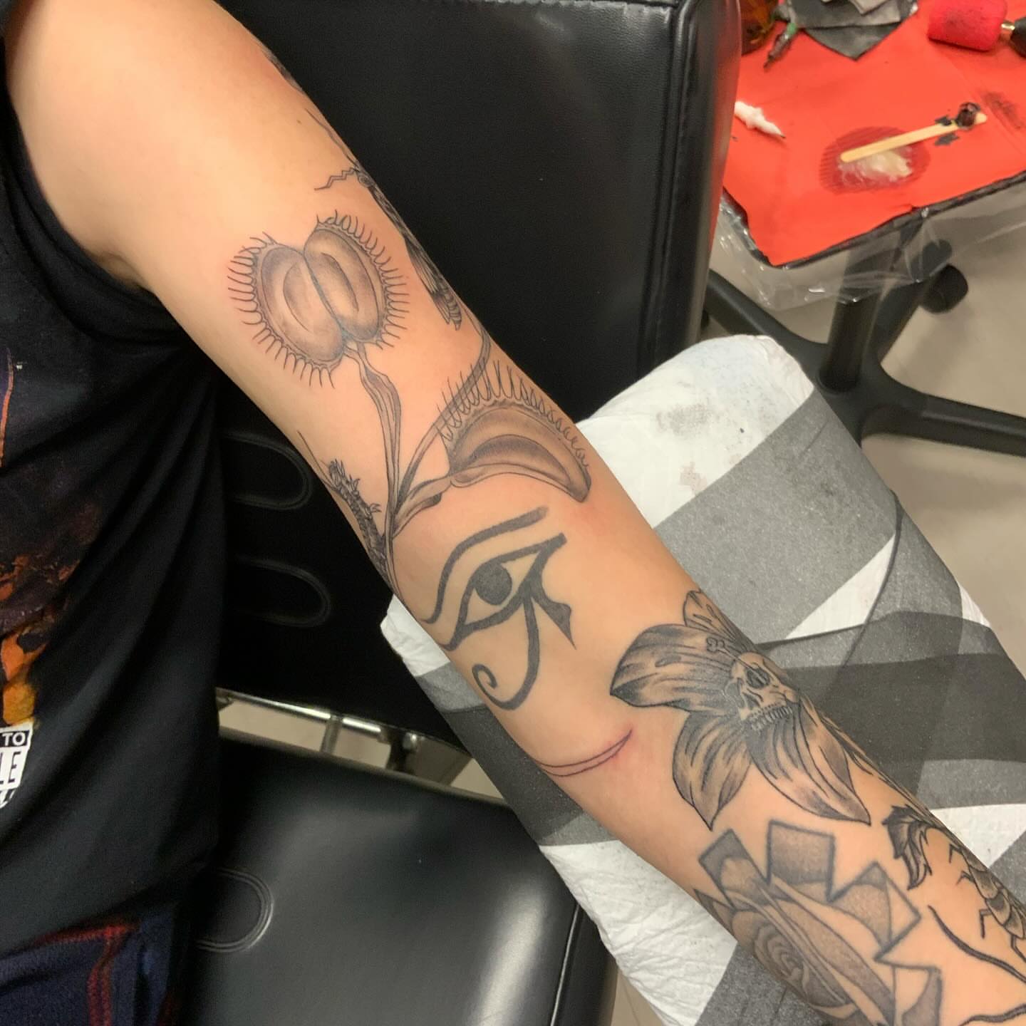 Eye and lily black and grey tattoo on the forearm by QUEEN TATTOO Stephanie Larson