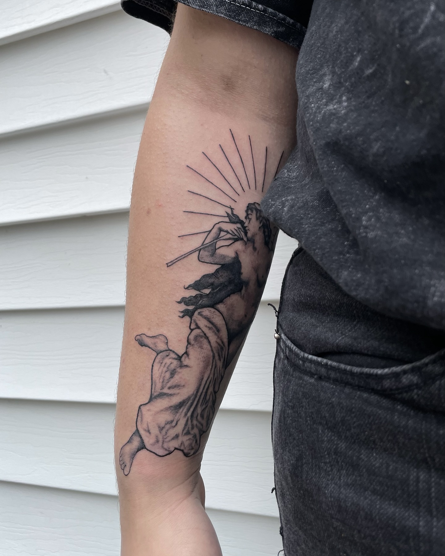 Flute player black and grey tattoo on the forearm by Liv