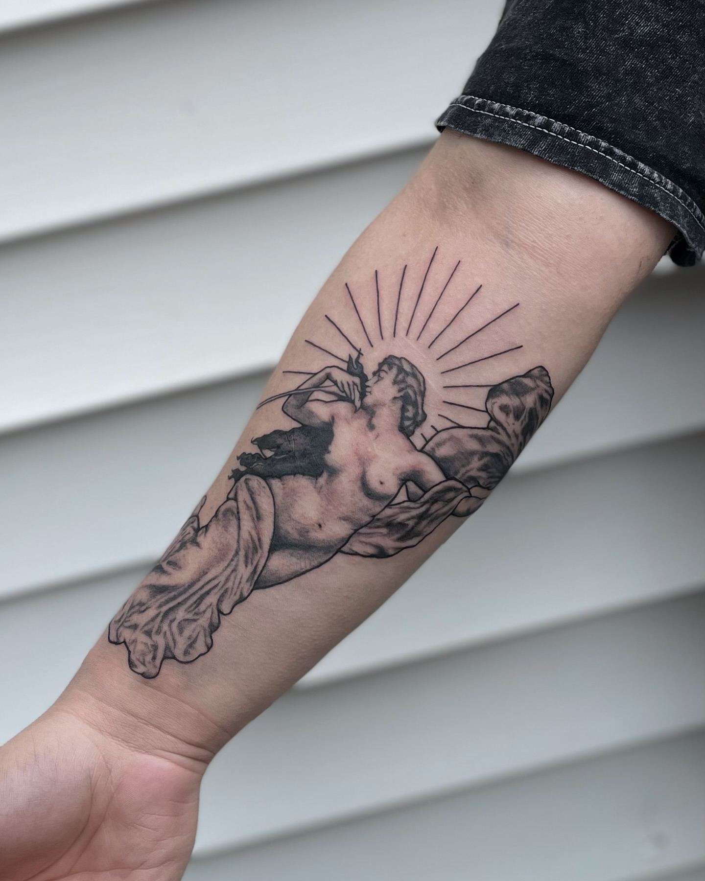 Nude angel black and grey tattoo on the forearm by Liv