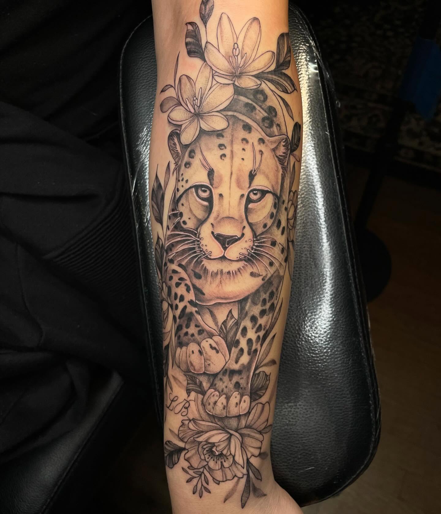 Cheetah and flowers realism tattoo on the forearm by Lauren Sisouphanh, Canton, Ohio
